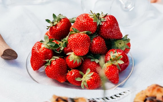 Fraises de Carpentras dans une assiette sur une table avec une nappe blanche  © O'Brien