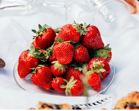 Fraises de Carpentras dans une assiette sur une table avec une nappe blanche  © O'Brien